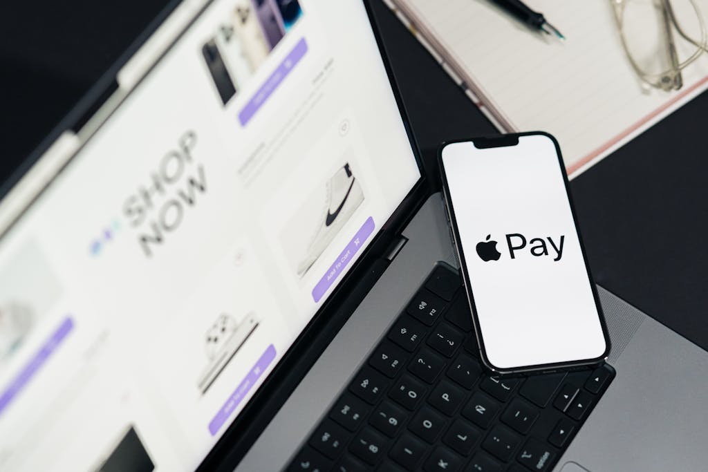 Laptop and smartphone display facilitating online shopping using mobile payment technology.